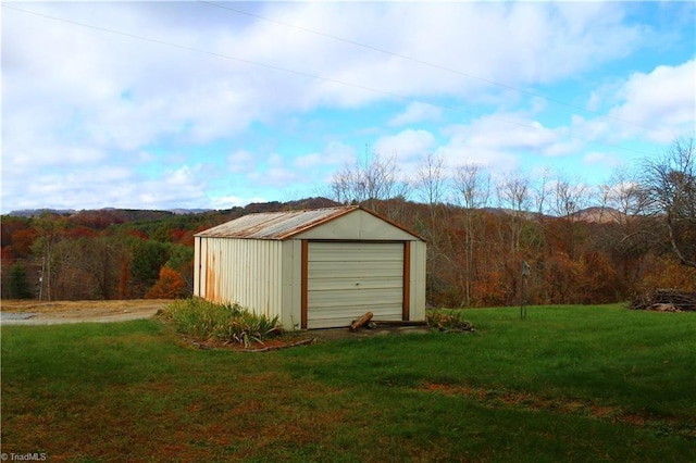 view of outdoor structure with an outbuilding and a wooded view