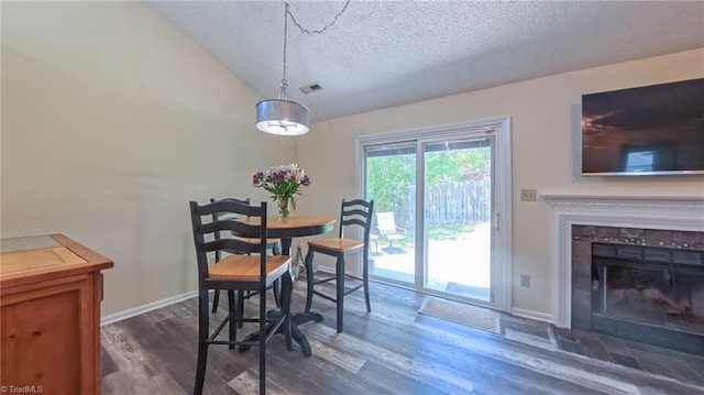 4401 Barndale Ct, Jamestown, NC 27282 - dining area with a textured ceiling, vaulted ceiling, dark wood-type flooring, and a tile fireplace