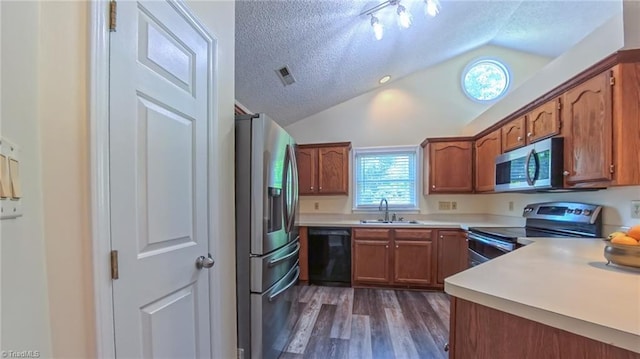 4401 Barndale Ct, Jamestown, NC 27282 - kitchen with appliances with stainless steel finishes, a textured ceiling, vaulted ceiling, dark wood-style flooring, and brown cabinets