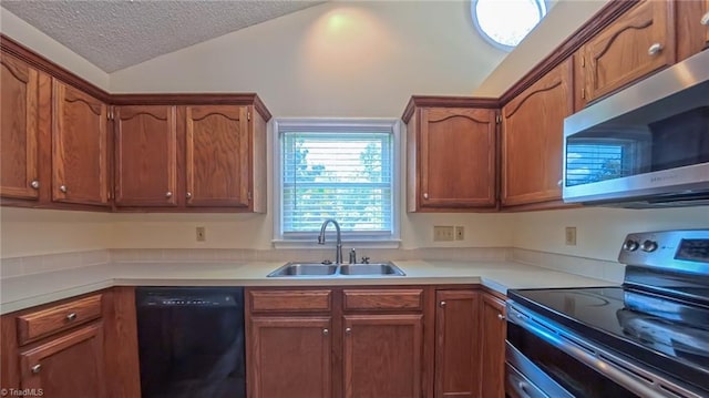 4401 Barndale Ct, Jamestown, NC 27282 - kitchen with appliances with stainless steel finishes, lofted ceiling, a textured ceiling, light countertops, and brown cabinetry