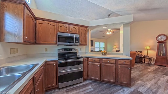 4401 Barndale Ct, Jamestown, NC 27282 - kitchen with stainless steel appliances, lofted ceiling, a textured ceiling, light countertops, and a ceiling fan