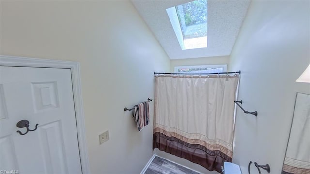 4401 Barndale Ct, Jamestown, NC 27282 - full bath with a skylight, vaulted ceiling, a shower with curtain, and wood finished floors