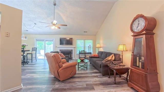 4401 Barndale Ct, Jamestown, NC 27282 - living room with ceiling fan, a textured ceiling, healthy amount of natural light, a fireplace with raised hearth, and lofted ceiling