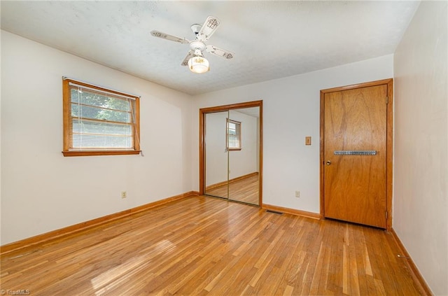unfurnished bedroom featuring a closet, visible vents, baseboards, a ceiling fan, and light wood-style flooring