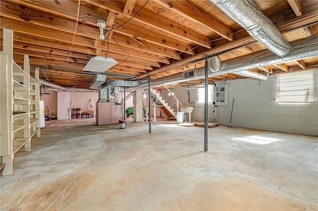 below grade area featuring heating unit, stairs, and visible vents