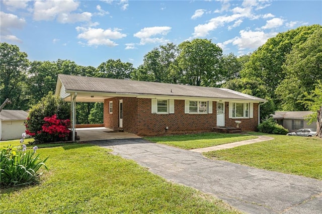 ranch-style house featuring a carport, aphalt driveway, a front lawn, and brick siding