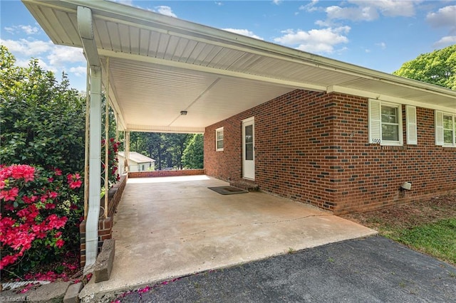 view of side of property featuring brick siding, entry steps, and a carport