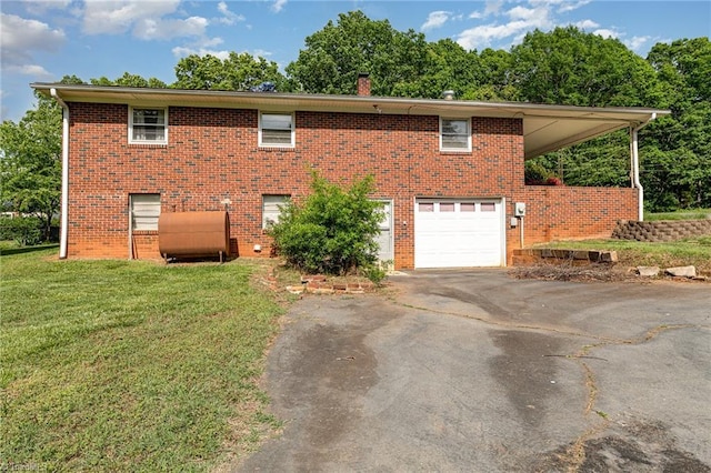 view of home's exterior with an attached garage, aphalt driveway, heating fuel, brick siding, and a lawn