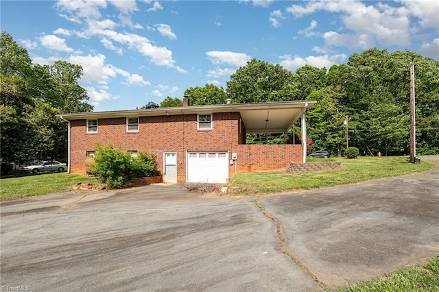 view of side of home with a lawn, brick siding, driveway, and a garage