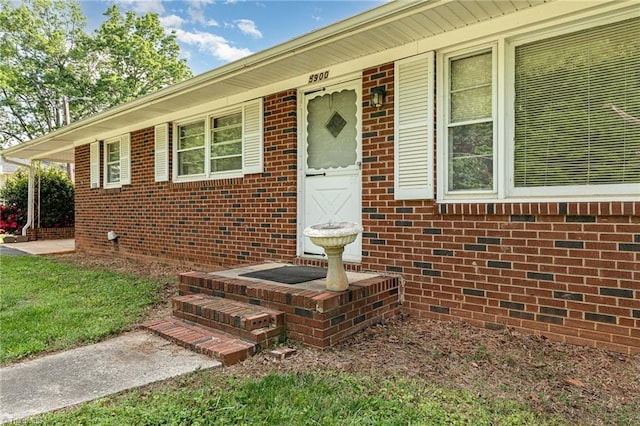 view of exterior entry with brick siding