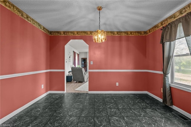 2719 NC Highway 87, Graham, NC 27253 - unfurnished room featuring plenty of natural light, a textured ceiling, arched walkways, a chandelier, and baseboards