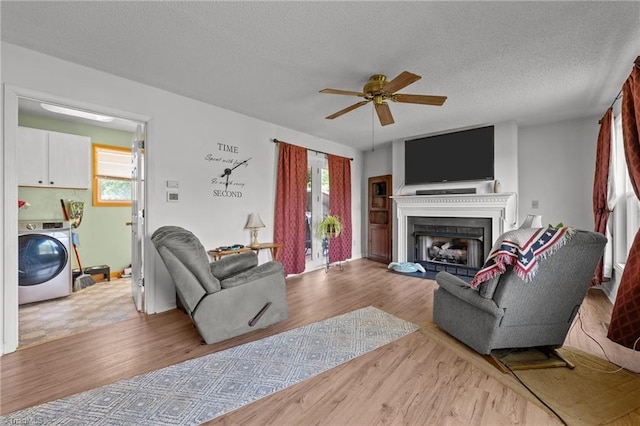 2719 NC Highway 87, Graham, NC 27253 - living area with washer / clothes dryer, a ceiling fan, wood finished floors, a textured ceiling, and a fireplace
