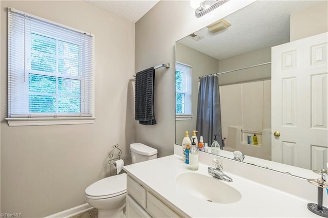 bathroom featuring toilet, a textured ceiling, a shower with curtain, vanity, and baseboards