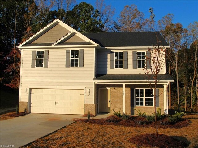 craftsman house featuring driveway, a garage, and brick siding