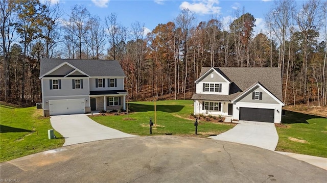 traditional home with driveway, an attached garage, a front lawn, and a wooded view