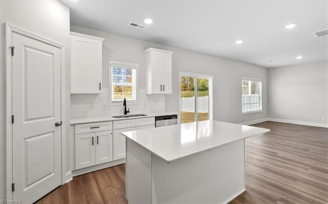 4196 Emmas Way E, Bend, NC 27018 - kitchen featuring stainless steel dishwasher, a sink, dark wood-style floors, light countertops, and decorative backsplash