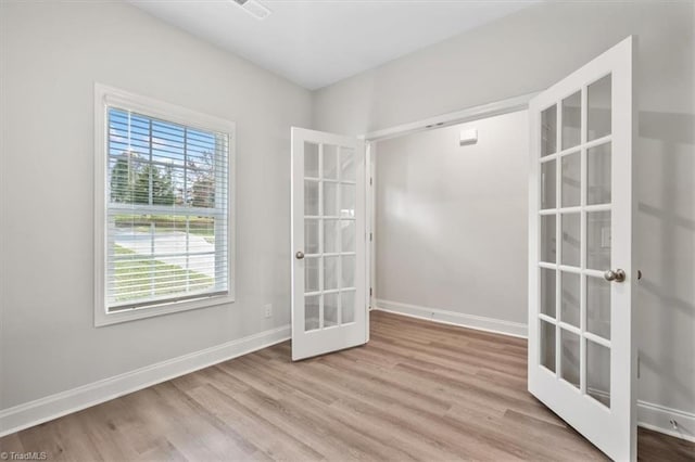 4196 Emmas Way E, Bend, NC 27018 - empty room with french doors, wood finished floors, and baseboards