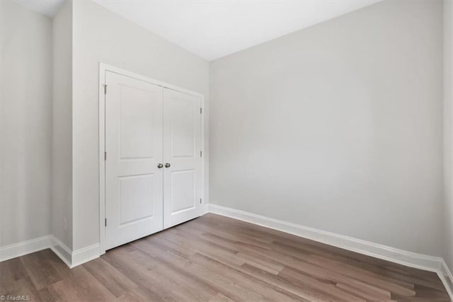 4196 Emmas Way E, Bend, NC 27018 - unfurnished bedroom featuring baseboards, wood finished floors, and a closet