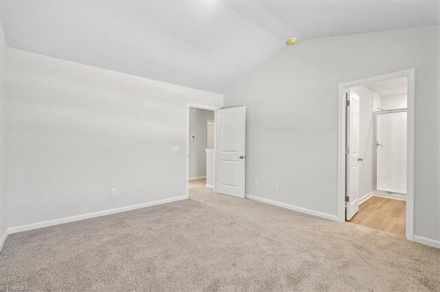 4196 Emmas Way E, Bend, NC 27018 - unfurnished bedroom with carpet flooring, vaulted ceiling, baseboards, and ensuite bathroom