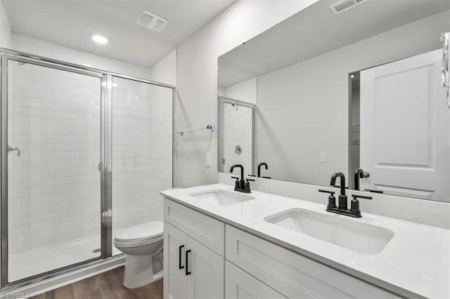 4196 Emmas Way E, Bend, NC 27018 - bathroom featuring wood finished floors, a shower stall, double vanity, and recessed lighting