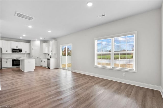 4196 Emmas Way E, Bend, NC 27018 - unfurnished living room with light wood-type flooring, recessed lighting, and baseboards