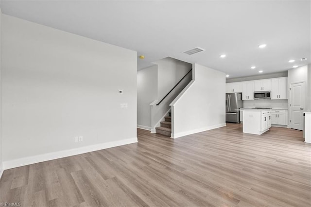 4196 Emmas Way E, Bend, NC 27018 - unfurnished living room featuring recessed lighting, light wood-type flooring, baseboards, and stairway