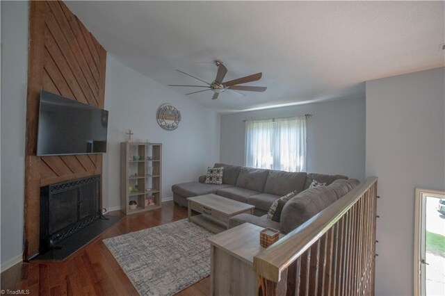 living area with ceiling fan, a fireplace with flush hearth, plenty of natural light, and wood finished floors
