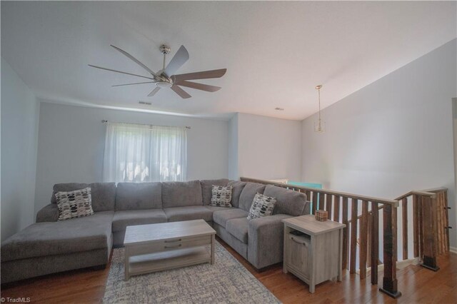 living room with light wood-style flooring, ceiling fan, and vaulted ceiling