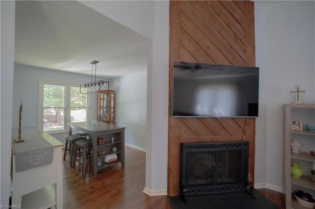 living room with a tile fireplace, wood finished floors, and baseboards