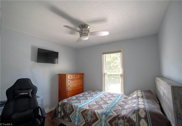 bedroom featuring a textured ceiling, wood finished floors, and ceiling fan