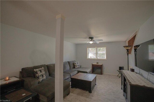 living room featuring a ceiling fan, light colored carpet, and baseboards