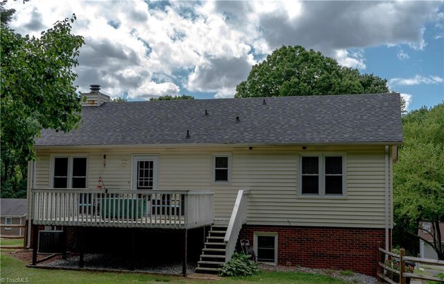 back of house featuring a wooden deck, stairs, central AC, a shingled roof, and a chimney