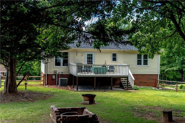 back of property featuring a wooden deck, stairs, and a fire pit