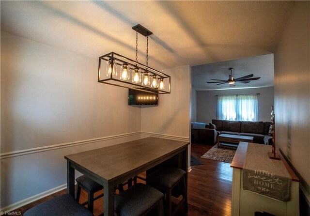 dining room featuring dark wood-type flooring, ceiling fan, and baseboards