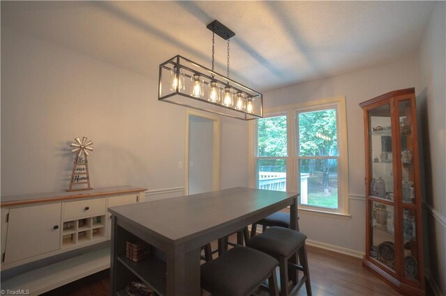 dining space with dark wood-style floors and baseboards