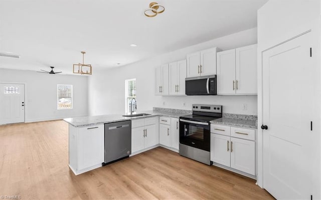 kitchen featuring kitchen peninsula, stainless steel appliances, white cabinetry, and sink