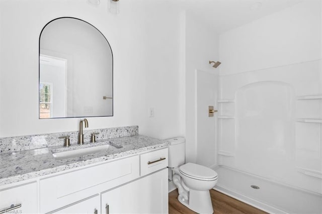 bathroom with vanity, toilet, wood-type flooring, and walk in shower