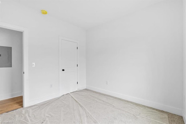 unfurnished bedroom featuring light carpet and electric panel