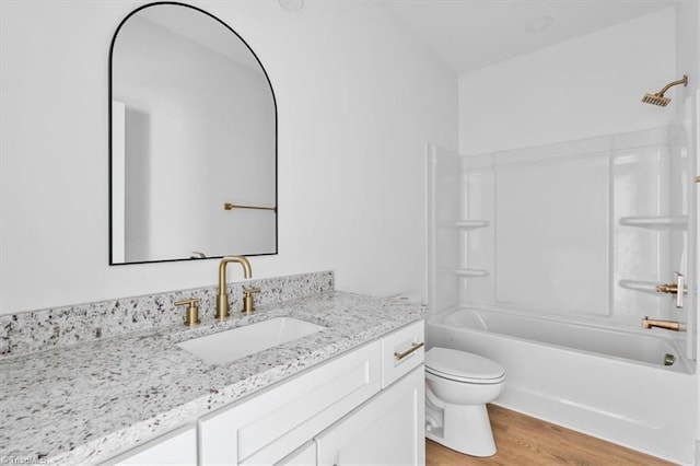 full bathroom featuring toilet, wood-type flooring, vanity, and bathing tub / shower combination