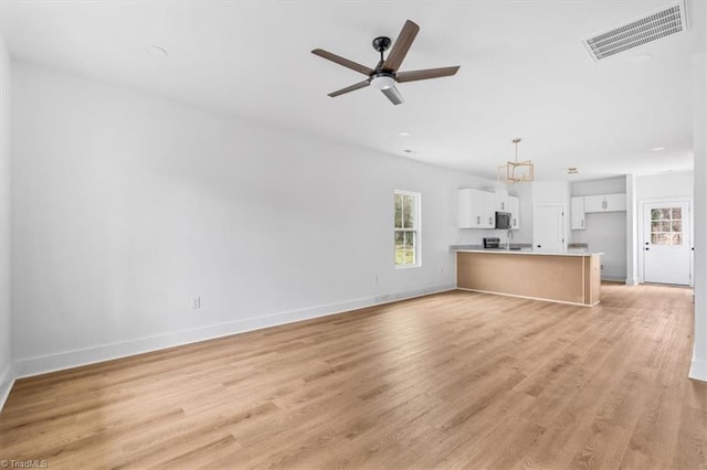 unfurnished living room featuring ceiling fan and light hardwood / wood-style floors