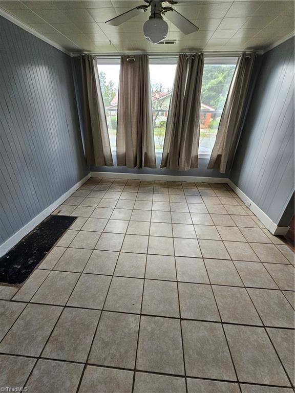 tiled empty room with ceiling fan and plenty of natural light