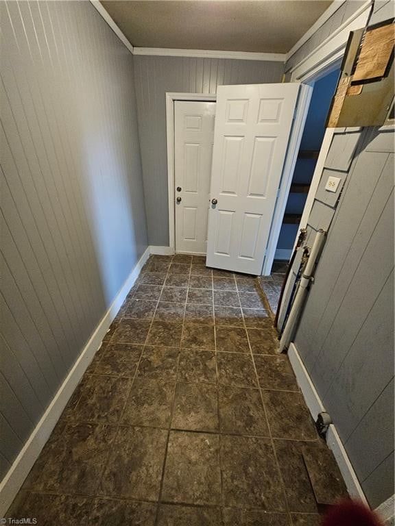 hallway with crown molding and wooden walls