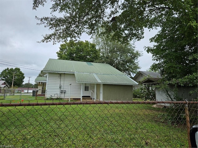 rear view of house featuring a yard