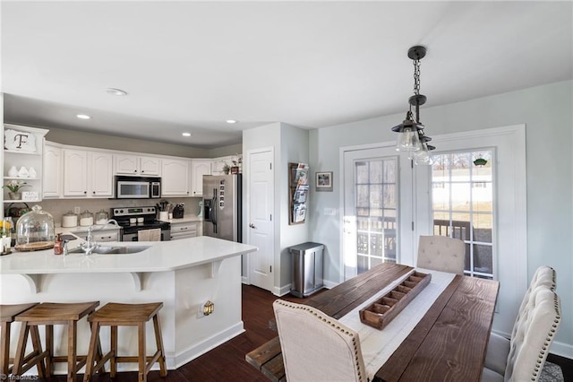 kitchen with open shelves, a breakfast bar, a peninsula, stainless steel appliances, and dark wood-style flooring