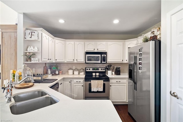 kitchen with a sink, decorative backsplash, white cabinetry, and stainless steel appliances