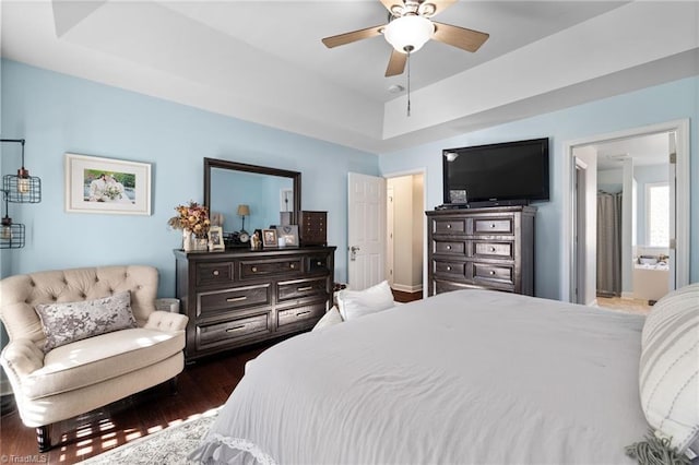 bedroom featuring a tray ceiling, baseboards, ceiling fan, and dark wood-style flooring