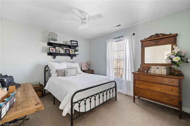 carpeted bedroom with a ceiling fan, visible vents, and baseboards