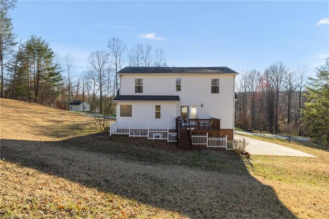 rear view of property featuring a deck and a yard