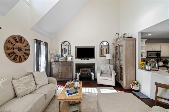 living area featuring baseboards, a fireplace, dark wood-style flooring, and high vaulted ceiling