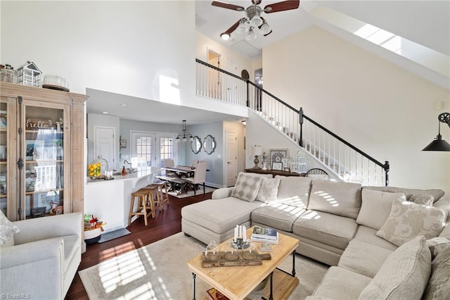 living area featuring stairway, high vaulted ceiling, wood finished floors, and a ceiling fan